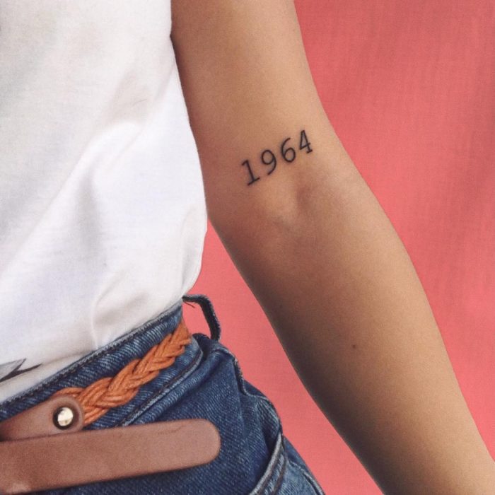 Tatuaje de números en la parte superior interna del brazo