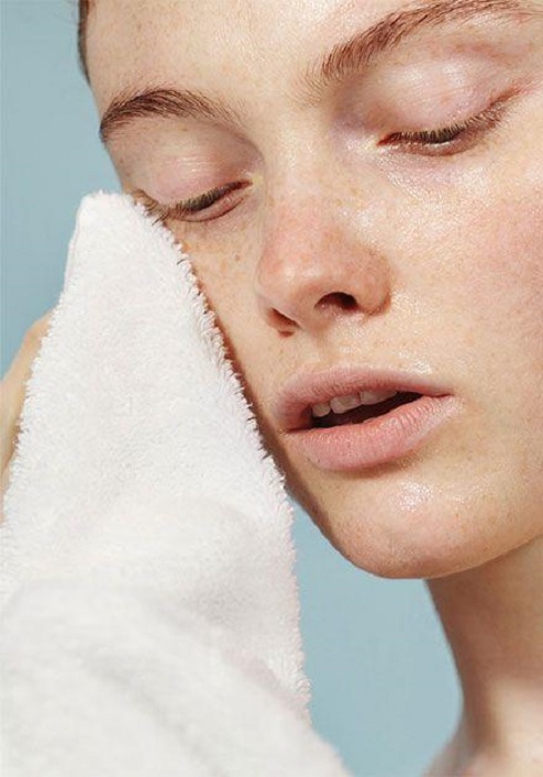 Chica aplicando toallas frías sobre su rostro