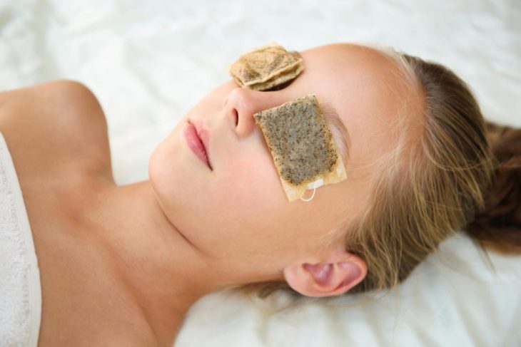 Chica con bolsas de té en los ojos para reducir el cansancio visual