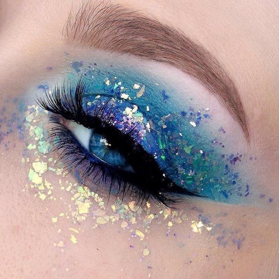 Maquillaje de sombra en azul, morado y glitters metalizados