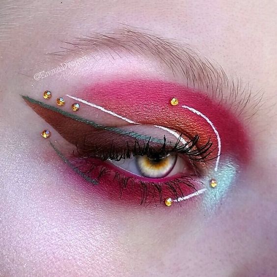 Sombra para ojos en tonos rojos, rosas y amarillos con delineado en tono blanco