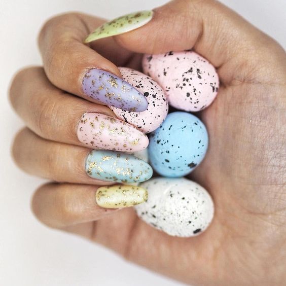 Manicura en tonos pastel con efecto metalizado y puntos inspirados en huevos de dinosaurio