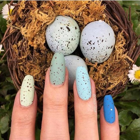 Manicura en tonos azules y verdes con puntos inspirados en huevos de dinosaurio