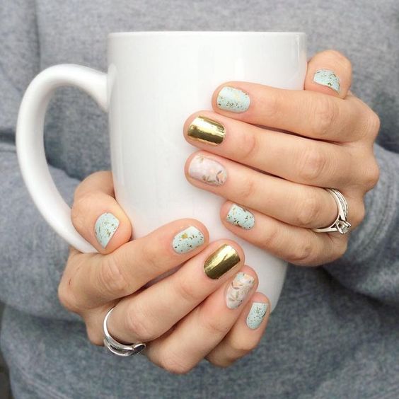 Manicura alternada con uñas doradas, tonos pastel y puntos inspirados en huevos de dinosaurio