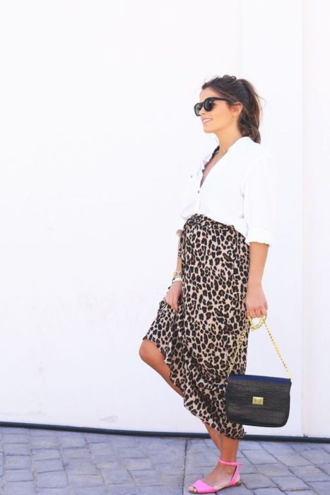 Chica embarazada usando un vestido de leopardo con una camisa blanca
