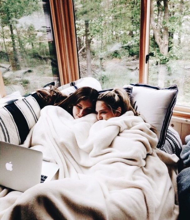 Amigas viendo una película en el sofá