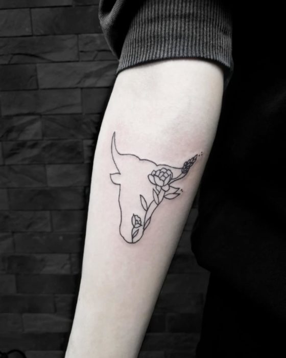 Tatuaje del signo de Tauro sobre el antebrazo en tinta negra