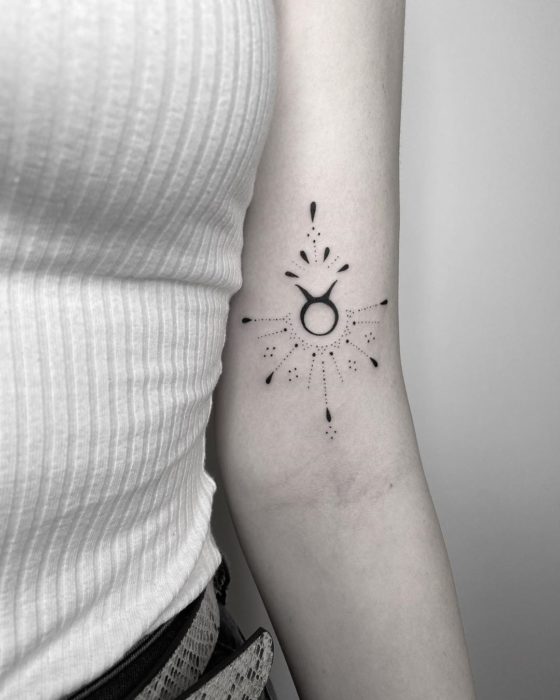 Tatuaje del signo de Tauro sobre el antebrazo en tinta negra