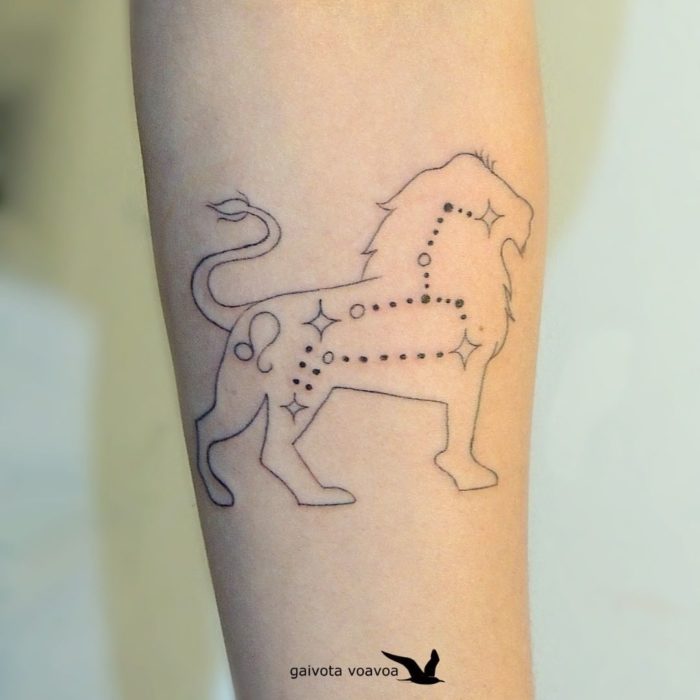 Tatuaje de la constelación de Leo con la silueta de un león rodeándola en el antebrazo