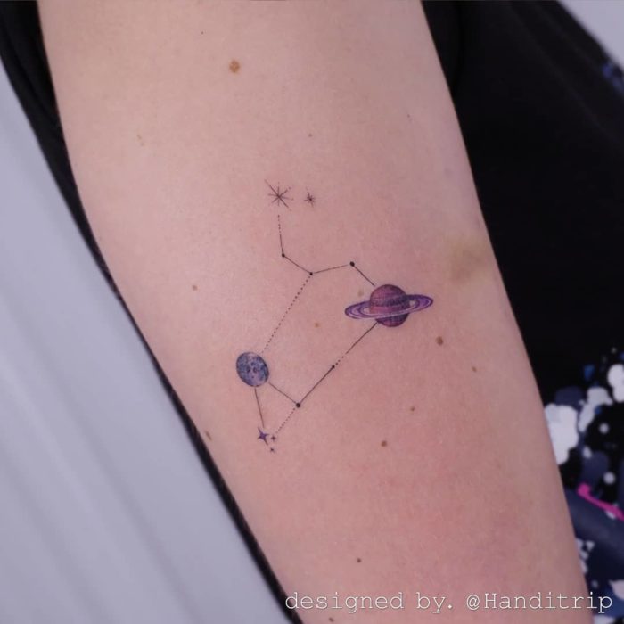 Tatuaje de la constelación de Leo en tinta negra y a color en el antebrazo