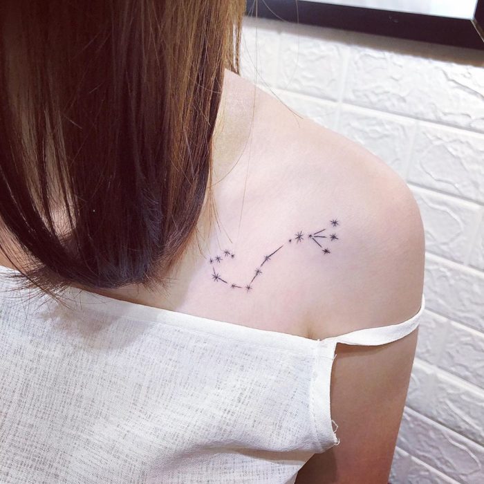 Tatuaje de la constelación de Escorpio en tinta negra en las clavículas