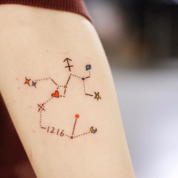 Tatuaje de la constelación de Sagitario a color en el antebrazo