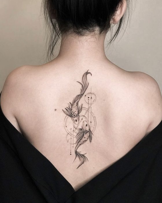 Tatuaje de Piscis en la parte alta de la espalda con tinta negra