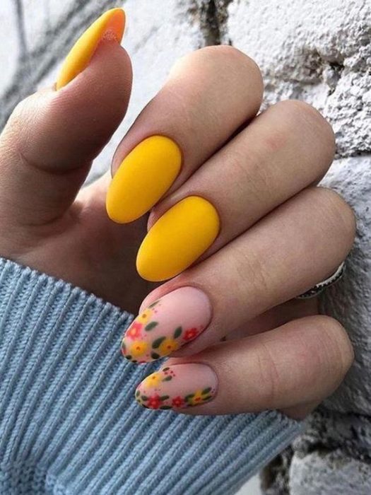Manicura estilo francés con flores en dos uñas y en contraste con amarillo y naranja en guías verdes