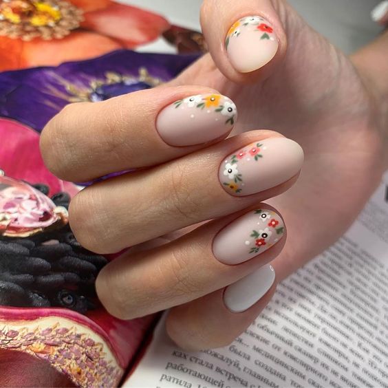 Manicura estilo francés con mini flores en blanco, amarillo y rojo