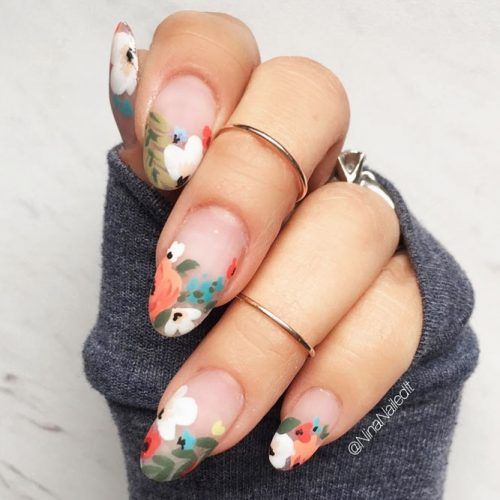 Manicura estilo francés con flores blancas, azul, naranja y amarillo