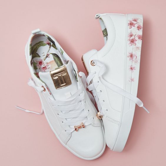 Tenis blancos con flores en rosa en los costados de la suela