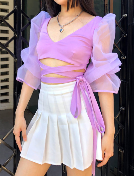 Top morado de mangas de tela transparente, gigot, con falda blanca de estudiante