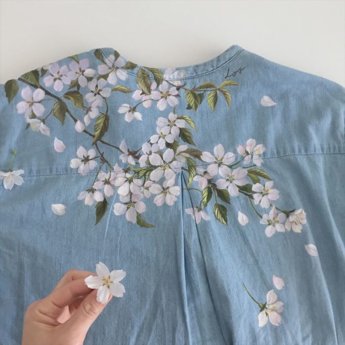 Camisa tipo denim con hojas verdes y flores de árbol de cerezo color blanco