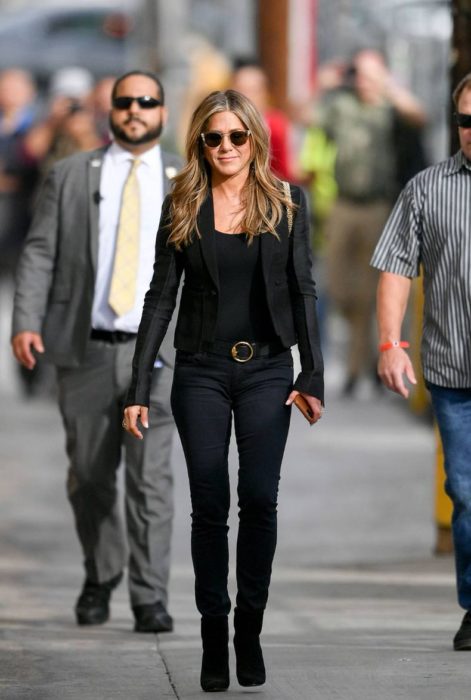 Jennifer Aniston caminando por la calle mientras usa un total black look