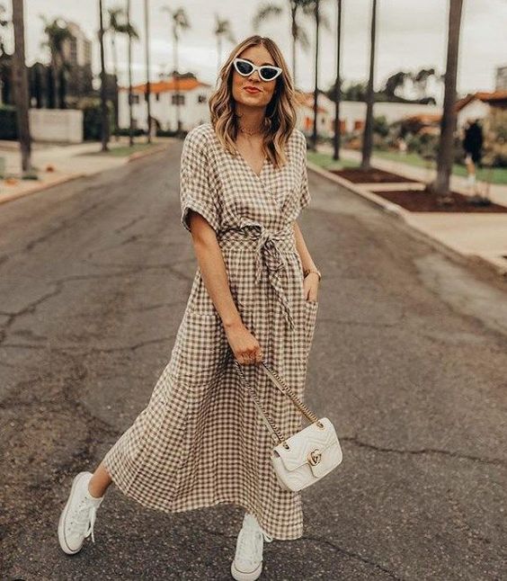 Chica llevando vestido largo con estampado a cuadros estilo wrap