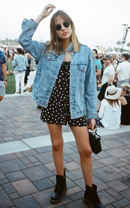 Vestido negro floreado, botas tipo Dr. Martens y chaqueta oversized con lentes de sol