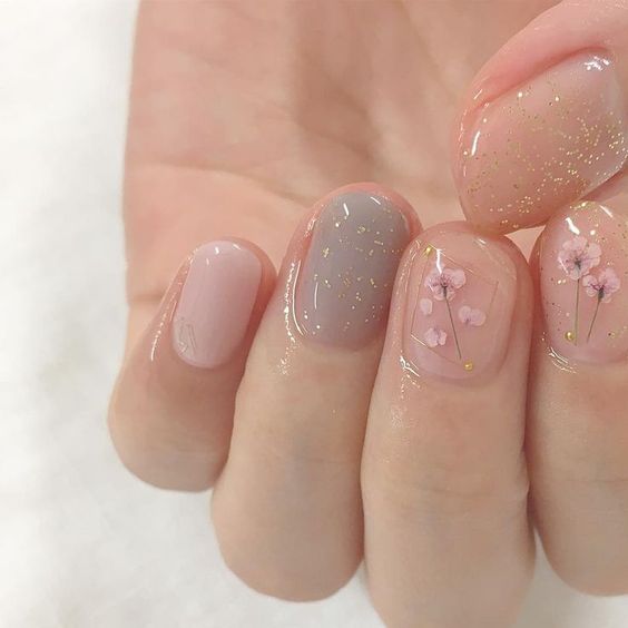 Manicura en tono rosa pastel con un toque floral hecho a mano