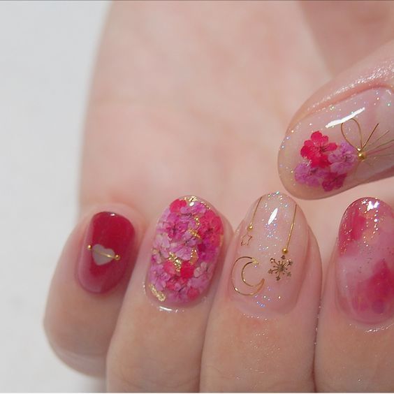 Manicura en tono rosa fucsia con flores doradas en miniatura