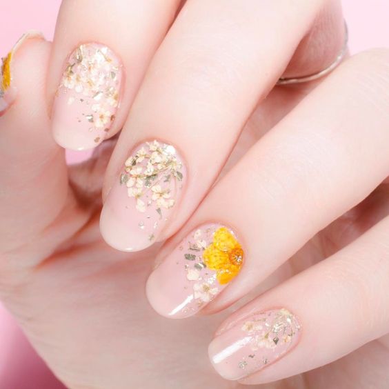 Manicura en efecto cristal con margaritas y girasoles