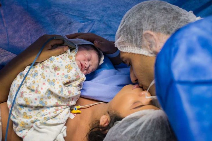Papás de la bebé que nació enojada, sosteniendo a la pequeña en brazos 