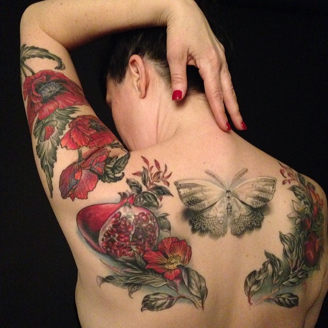 Tatuaje sobre la espalda, se extiende sobre el antebrazo y una mariposa sobre el centro de la espalda alta