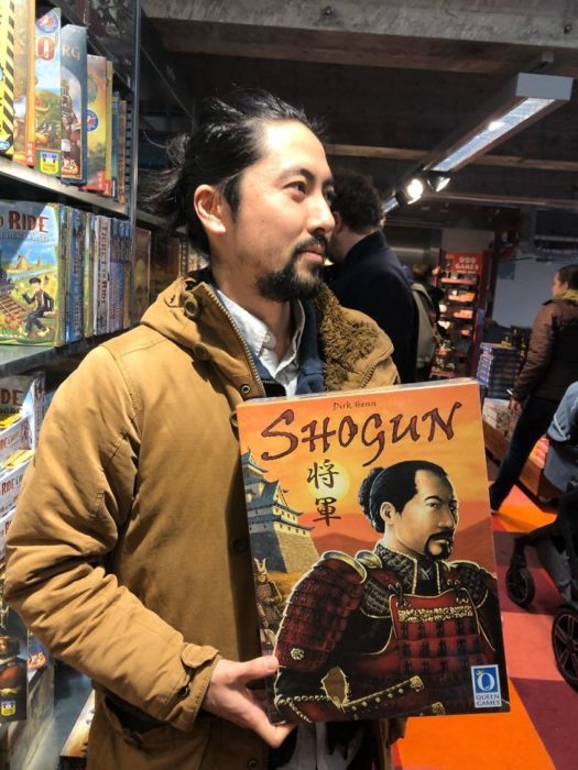 Hombre con rasgos asiáticos sosteniendo un libro japones