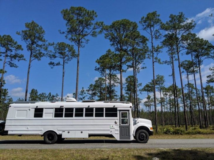 Autobús escolar blanco viajando por la carretera