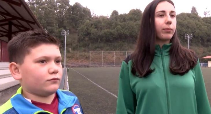 Niño y niña en una cancha de fútbol siendo entrevistados