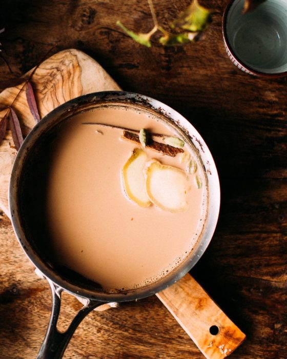 Té chai en olla sobre mes de madera