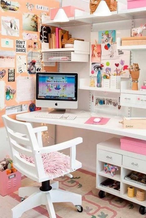 Escritorio alegre, silla y repisas blancas, posters y postales en la pared