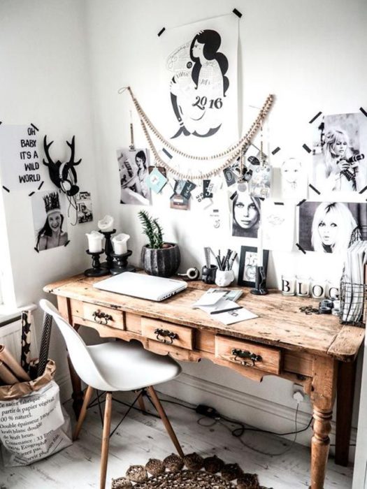 Habitación blanca, silla blanca de cuatro patas y escritorio vintage de madera, con posters en la pared