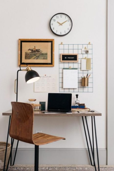 Área de escritorio con mesa y silla de madera y soporte de metal