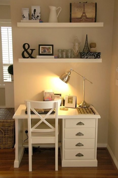Área de trabajo con luz amarilla, muebles blancos y repisas decoradas