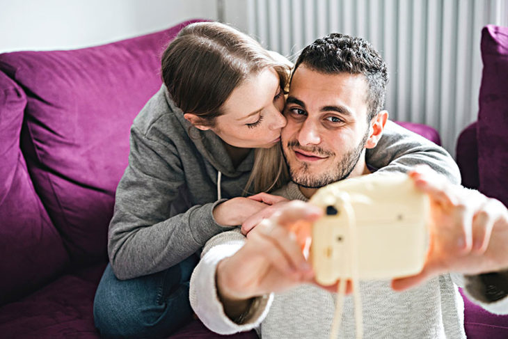 Pareja tomando fotos con cámara instantánea