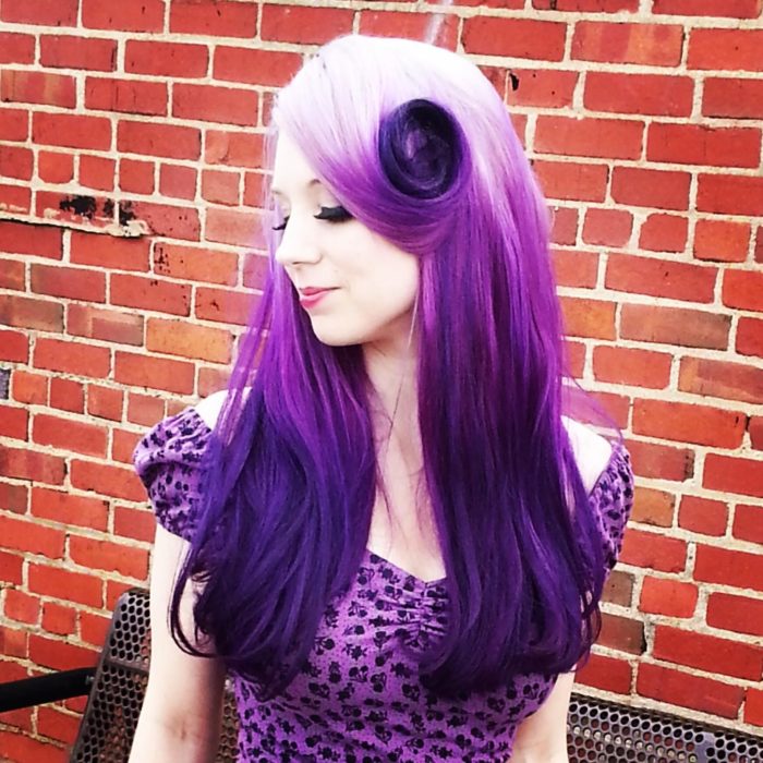 Chica con el cabello morado y un peinado en forma de rosa