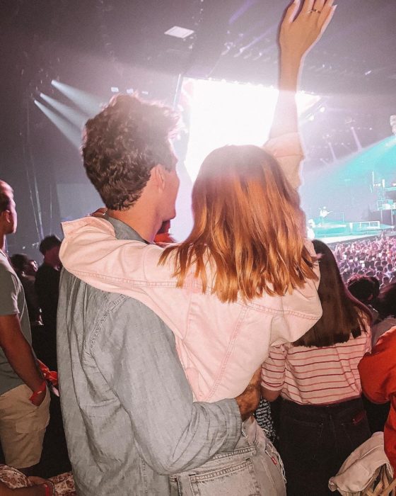 Pareja de novios abrazados mientras están en un concierto 