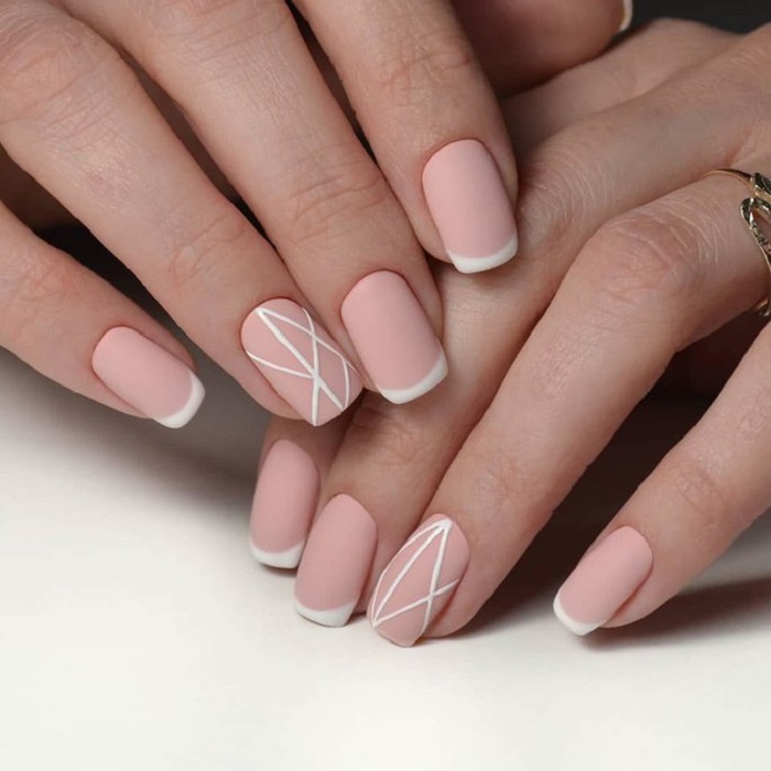 Manicura rosa pastel con detalles en blanco y efecto mate