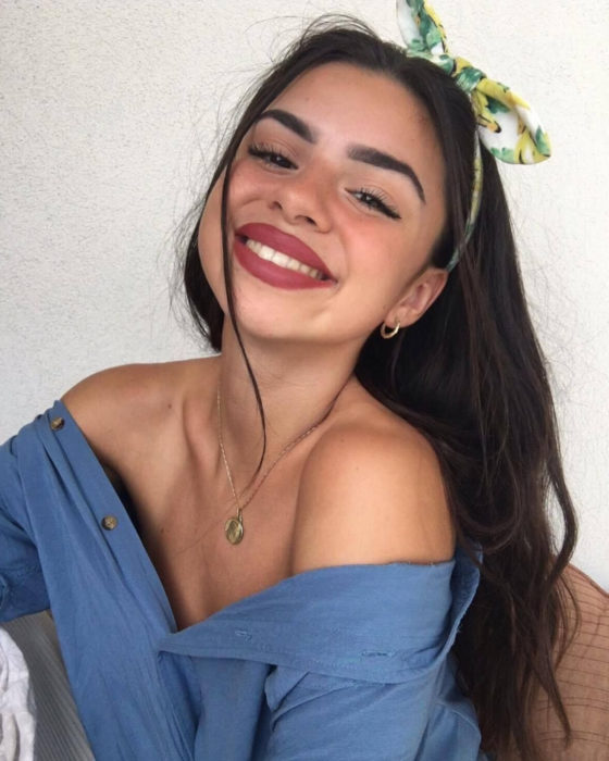 Peinados para San Valentín; chica sonriendo, con cabello castaño, lacio, suelto y diadema de tela