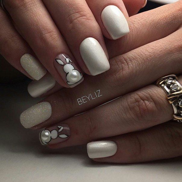 Chica con las uñas de las manos pintadas de color blanco con un conejito