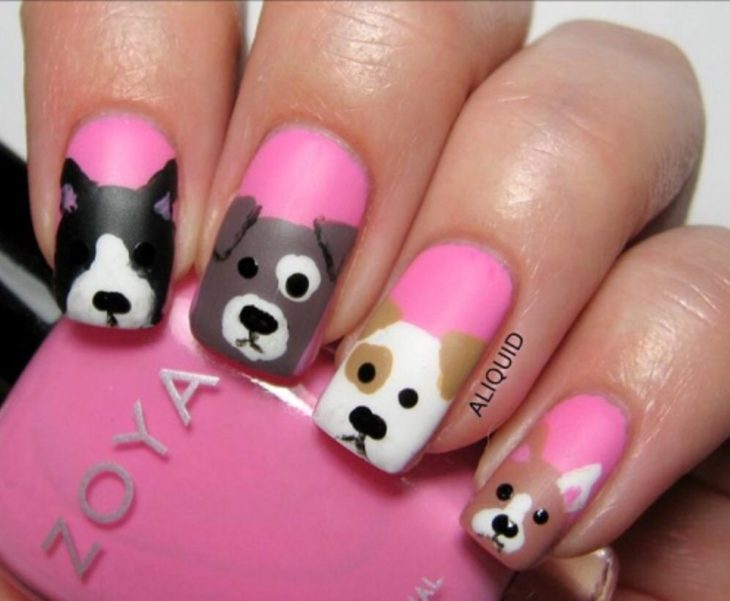 Chica con las uñas de las manos pintadas de color rosa y con perritos