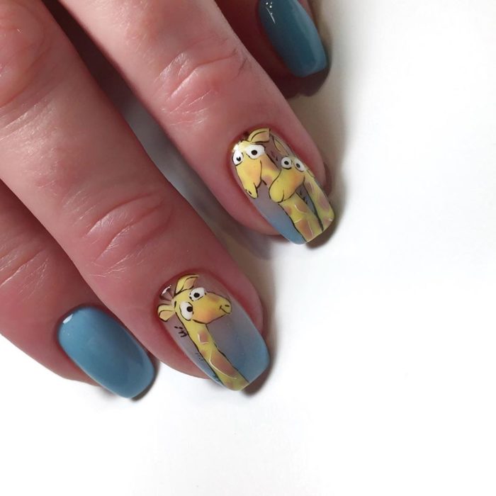 Uñas pintadas de color gris con una jirafa