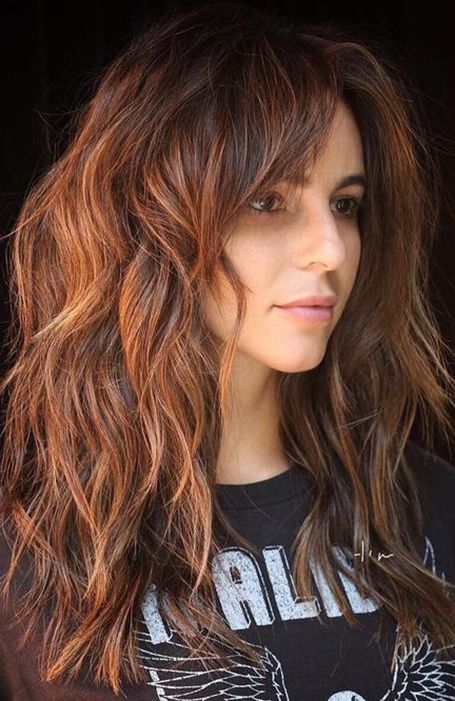 Chica con cabello rojizo cortado en shag posando de perfil