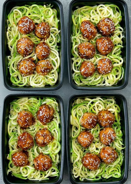 Comida con espagueti verde, albóndigas y ajonjolí