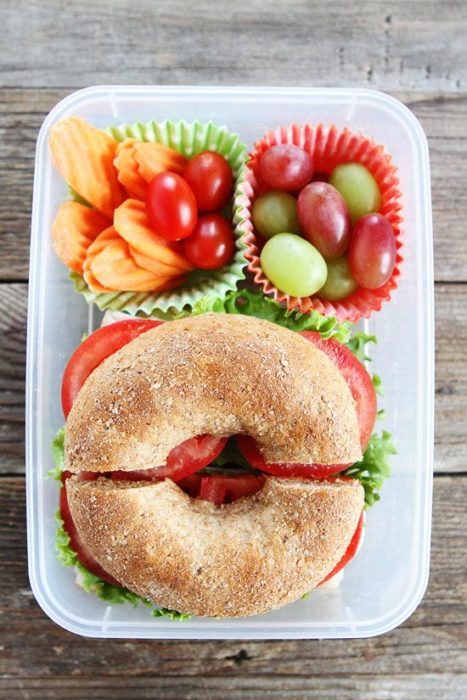 Bagel con tomate, lechuga, uvas rojas y verdes, tomate cherry y papas fritas